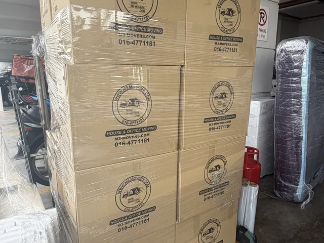 Stack of M3 Movers branded moving boxes ready to load