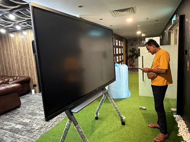 Mover preparing a large display screen at an office relocation