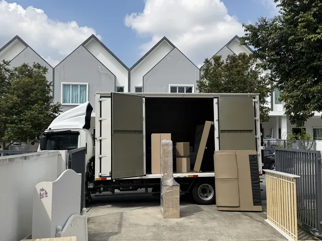 Lorry being loaded outside a row of terrace houses