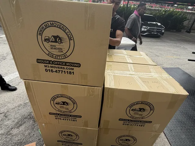 Branded M3 Movers boxes stacked on a trolley