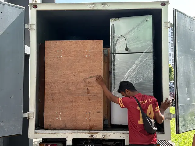 Mover loading a wooden crate into the lorry