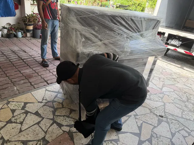 Movers lifting a wrapped cabinet